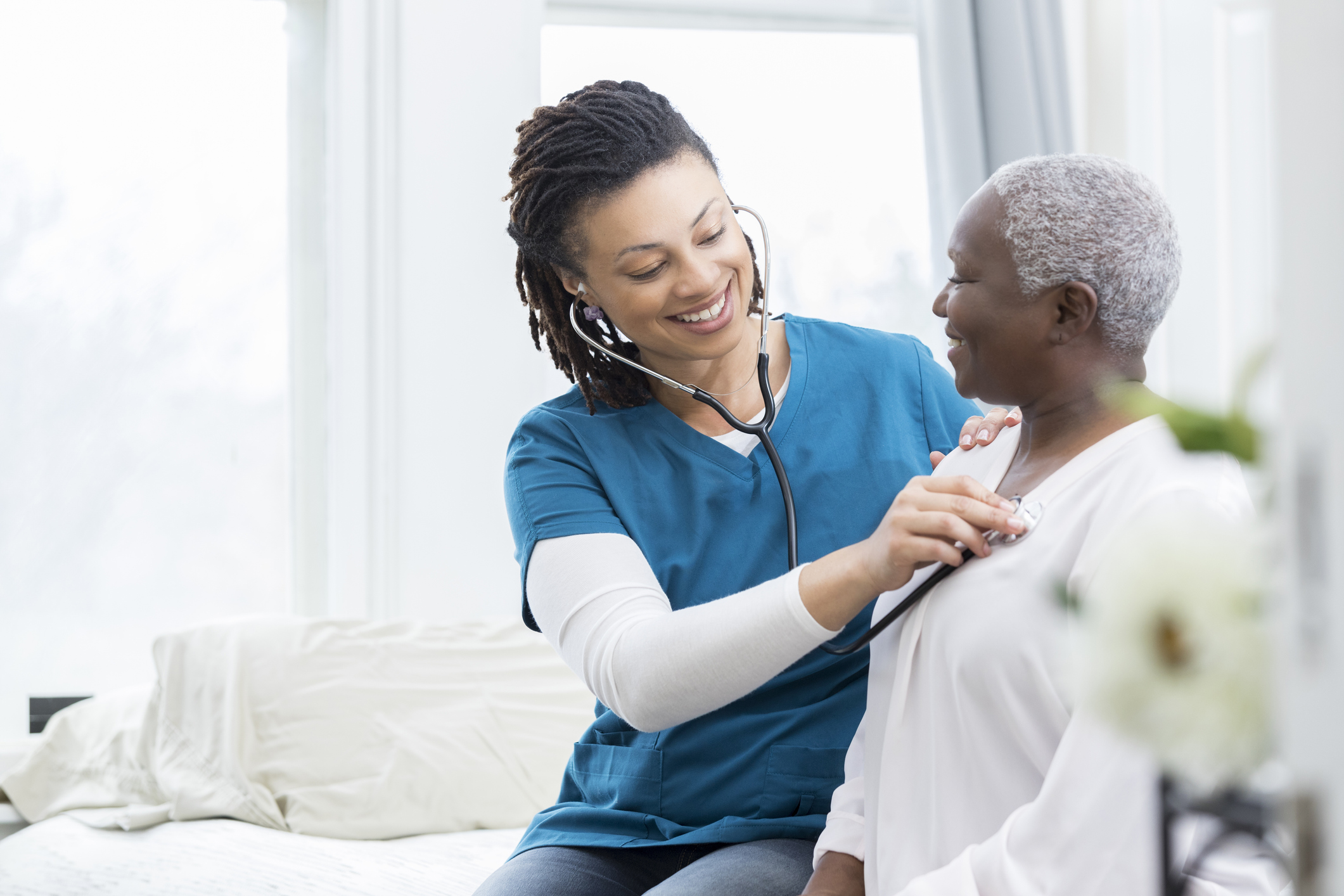 Home health nurse smiling with elderly patient